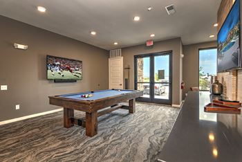 A games room with a pool table and a tv